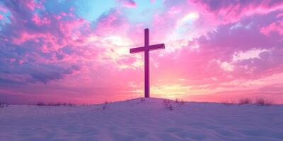 Cross silhouette at sunset over snowy landscape with vibrant clouds and soft light photo