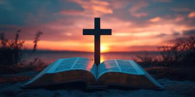 Sunset view with an open Bible and a cross silhouetted against the horizon photo