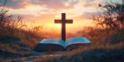 Cross placed on an open Bible during a peaceful sunset in a natural setting photo