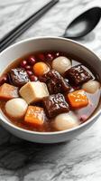 Delicious dessert bowl featuring sweet soup with fruit balls and tofu served in a modern setting photo