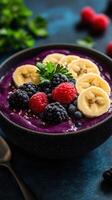 Delicious smoothie bowl topped with fresh fruits and seeds in a stylish black bowl on a blue background photo
