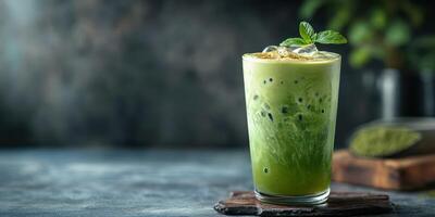 Refreshing green iced matcha drink served in a clear glass with mint garnish on a wooden coaster photo