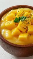 Delightful mango dessert served in a wooden bowl garnished with mint leaves and a hint of greenery photo