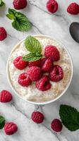 Delicious dessert with fresh raspberries and mint on a marble surface photo