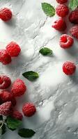 Fresh raspberries and mint leaves arranged on a light textured surface create a vibrant, appetizing display photo