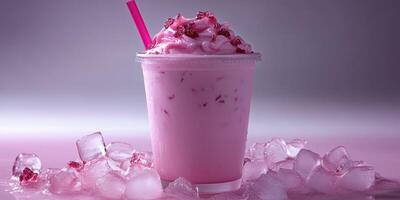 Refreshing pink beverage served in a clear cup with ice scattered around in a cool setting photo