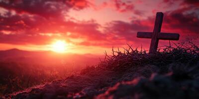 Uplifting sunset over a wooden cross surrounded by thorns on a hillside photo