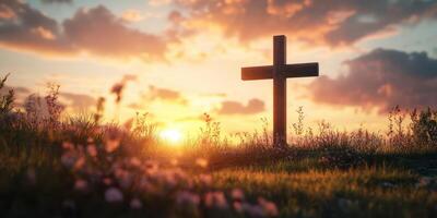 Sunset casting warm light over a wooden cross in a peaceful field filled with flowers photo