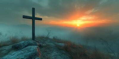Sunrise over a misty landscape with a cross on a rocky hilltop photo
