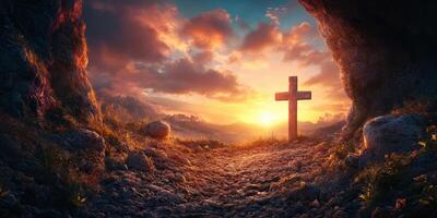 Cross standing in a cave at sunrise overlooking a lush landscape with dramatic clouds photo