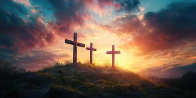 Three wooden crosses stand against a vibrant sunset in a serene landscape at dusk photo