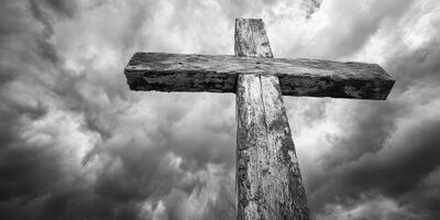 Wooden cross stands against dramatic sky filled with dark clouds in a solemn landscape photo