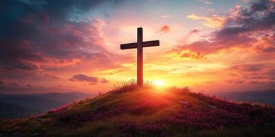 Cross silhouetted against a vibrant sunset with colorful clouds over a hilltop adorned with flowers during golden hour photo