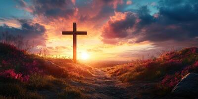 Cross stands tall against a vibrant sunset in a serene landscape filled with flowers photo