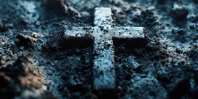 Cross engraved in dark soil reflects depth of faith and remembrance in a quiet graveyard setting at dusk photo