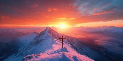 Sunset over snowy mountain peak with a cross silhouette against vibrant sky photo