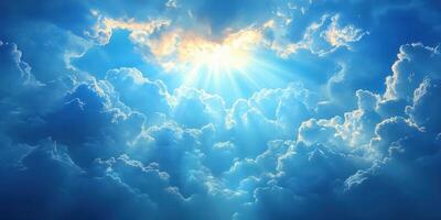 Bright sunlight breaking through fluffy clouds in a clear blue sky at midday photo