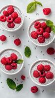Fresh raspberry chia pudding served in bowls with mint leaves on a textured white surface photo
