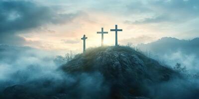 Three crosses stand on a misty hilltop during dawn with fog enveloping the landscape and distant mountains in the background photo