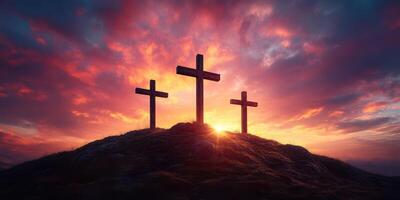 Three crosses silhouetted against a vibrant sunset sky in a serene landscape photo