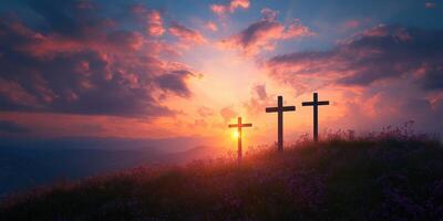Three crosses silhouetted at sunset over a tranquil landscape with colorful clouds and distant mountains photo