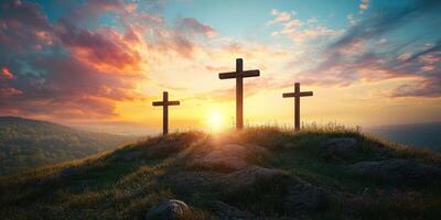 Three crosses stand on a hill at sunset surrounded by colorful clouds and nature in a peaceful landscape photo