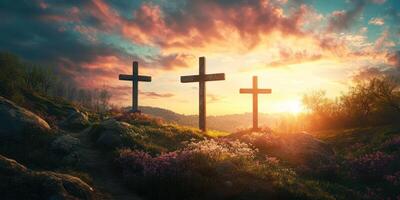 Sunset over three crosses on a grassy hill surrounded by blooming flowers and trees photo