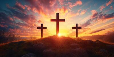 Silhouetted crosses against a vibrant sunrise over rolling hills photo