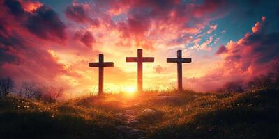 Sunset illuminates three crosses on a hill under a colorful sky with clouds photo