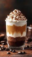 Layers of flavored coffee dessert in a glass topped with whipped cream and cocoa powder photo