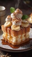 Delicious dessert featuring layers of fluffy bread, bananas, whipped cream, and caramel sauce on a rustic wooden table photo