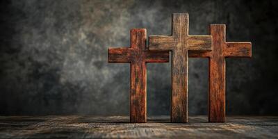 Three rustic wooden crosses displayed on a textured surface with a dark background creating a solemn atmosphere photo