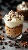Delicious layered dessert with whipped cream and chocolate shavings served in a glass cup on a dark background photo
