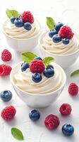 Dessert bowls filled with creamy yogurt topped with fresh berries and mint leaves in a bright kitchen setting photo