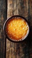Freshly brewed coffee in a dark cup on a rustic wooden table during morning hours photo