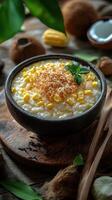 Delicious bowl of coconut rice pudding with corn and toasted coconut served at a rustic table photo