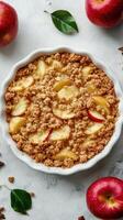 Freshly baked apple crumble dessert with a golden topping and slices of apple on a gray countertop photo