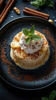 Delightful dessert served in a black dish topped with whipped cream and mint leaves on a dark table photo
