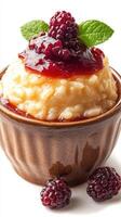 Delicious rice pudding topped with berry sauce and fresh blackberries in a rustic bowl photo