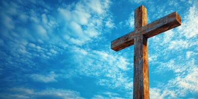 Rustic wooden cross stands tall against a vivid blue sky with fluffy clouds in a serene landscape photo