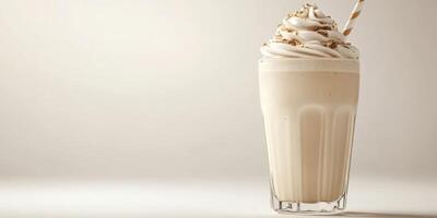 Creamy milkshake with whipped topping and a striped straw sits on a minimalist background photo