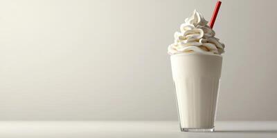 Creamy milkshake topped with whipped cream and a red straw in a glass on a neutral background photo