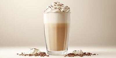 Creamy coffee beverage topped with whipped cream and cocoa powder in a clear glass, displayed on a neutral background photo