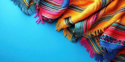 Colorful woven blankets displayed on a bright blue background in a vibrant setting for artistic purposes photo