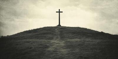 Cross atop a hill under an overcast sky at dusk with a winding path leading up to it photo