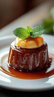 Delicious caramel dessert topped with banana and mint leaves served on a white plate photo