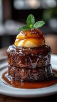 Delicious chocolate cake stacked high with caramel sauce and mint garnish served in a cozy cafe setting photo