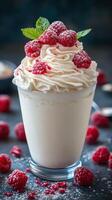 Delicious dessert drink topped with whipped cream and fresh raspberries in a stylish glass on a textured surface photo
