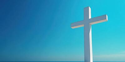 White cross stands against a clear blue sky over calm waters, symbolizing faith and hope on a serene day photo