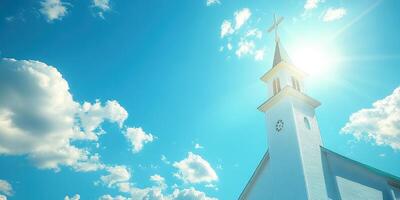 Bright sunlight shines over a church steeple against a blue sky with fluffy clouds in a serene daytime setting photo